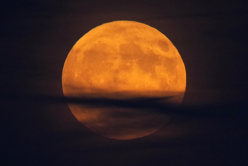 A supermoon rises behind clouds over Larnaca international airport in the eastern Mediterranean island of Cyprus, on Tuesday, Sept. 17, 2024. (AP Photo/Petros Karadjias)