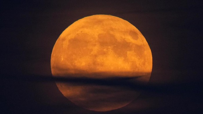 A supermoon rises behind clouds over Larnaca international airport in the eastern Mediterranean island of Cyprus, on Tuesday, Sept. 17, 2024. (AP Photo/Petros Karadjias)