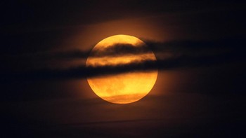 Bulan terbit di balik awan di atas Samudra Atlantik di lepas pantai Camden, Maine, Amerika Serikat, Selasa (17/9). Foto: AP/Petros Karadjias