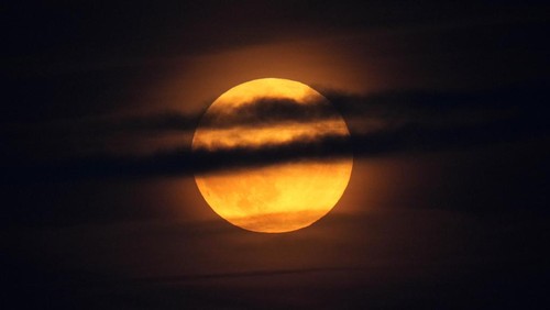A supermoon rises behind clouds over Larnaca international airport in the eastern Mediterranean island of Cyprus, on Tuesday, Sept. 17, 2024. (AP Photo/Petros Karadjias)