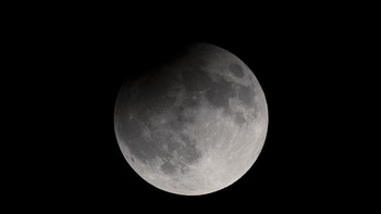 Gerhana Bulan sebagian menggelapkan supermoon yang terbit Selasa (17/9) di Nashville, Tennessee, Amerika Serikat. Foto: AP/Petros Karadjias