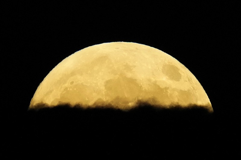 A supermoon rises behind clouds over Larnaca international airport in the eastern Mediterranean island of Cyprus, on Tuesday, Sept. 17, 2024. (AP Photo/Petros Karadjias)
