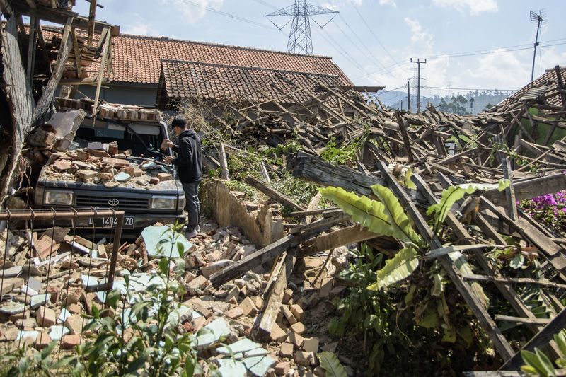 Warga melintas di dekat rumah yang rusak pascagempa bumi di Desa Cibeureum, Kertasari, Kabupaten Bandung, Jawa Barat, Rabu (18/9/2024). Menurut data sementara BPBD Provinsi Jawa Barat,  gempa berkekuatan 5.0 Magnitudo tersebut mengakibatkan 8 unit rumah, 2 fasilitas kesehatan, 1 sarana pendidikan, dan 1 tempat ibadah mengalami kerusakan. ANTARA FOTO/Novrian Arbi/Spt.
