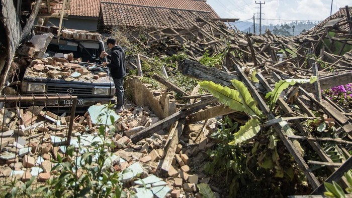Warga melintas di dekat rumah yang rusak pascagempa bumi di Desa Cibeureum, Kertasari, Kabupaten Bandung, Jawa Barat, Rabu (18/9/2024). Menurut data sementara BPBD Provinsi Jawa Barat,  gempa berkekuatan 5.0 Magnitudo tersebut mengakibatkan 8 unit rumah, 2 fasilitas kesehatan, 1 sarana pendidikan, dan 1 tempat ibadah mengalami kerusakan. ANTARA FOTO/Novrian Arbi/Spt.