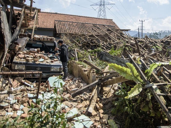 Warga melintas di dekat rumah yang rusak pascagempa bumi di Desa Cibeureum, Kertasari, Kabupaten Bandung, Jawa Barat, Rabu (18/9/2024). Menurut data sementara BPBD Provinsi Jawa Barat,  gempa berkekuatan 5.0 Magnitudo tersebut mengakibatkan 8 unit rumah, 2 fasilitas kesehatan, 1 sarana pendidikan, dan 1 tempat ibadah mengalami kerusakan. ANTARA FOTO/Novrian Arbi/Spt.