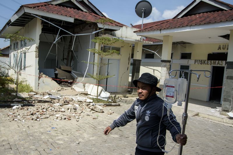 Warga melintas di dekat rumah yang rusak pascagempa bumi di Desa Cibeureum, Kertasari, Kabupaten Bandung, Jawa Barat, Rabu (18/9/2024). Menurut data sementara BPBD Provinsi Jawa Barat,  gempa berkekuatan 5.0 Magnitudo tersebut mengakibatkan 8 unit rumah, 2 fasilitas kesehatan, 1 sarana pendidikan, dan 1 tempat ibadah mengalami kerusakan. ANTARA FOTO/Novrian Arbi/Spt.