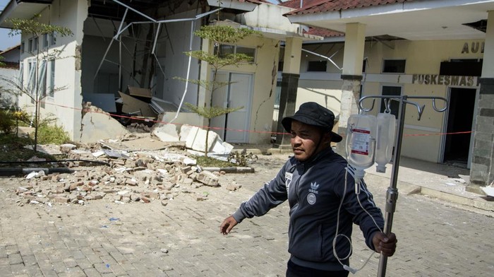 Warga melintas di dekat rumah yang rusak pascagempa bumi di Desa Cibeureum, Kertasari, Kabupaten Bandung, Jawa Barat, Rabu (18/9/2024). Menurut data sementara BPBD Provinsi Jawa Barat,  gempa berkekuatan 5.0 Magnitudo tersebut mengakibatkan 8 unit rumah, 2 fasilitas kesehatan, 1 sarana pendidikan, dan 1 tempat ibadah mengalami kerusakan. ANTARA FOTO/Novrian Arbi/Spt.