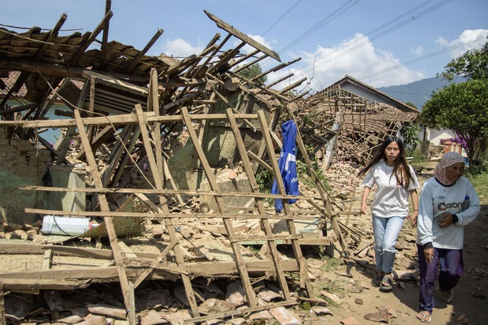 Warga melintas di dekat rumah yang rusak pascagempa bumi di Desa Cibeureum, Kertasari, Kabupaten Bandung, Jawa Barat, Rabu (18/9/2024). Menurut data sementara BPBD Provinsi Jawa Barat,  gempa berkekuatan 5.0 Magnitudo tersebut mengakibatkan 8 unit rumah, 2 fasilitas kesehatan, 1 sarana pendidikan, dan 1 tempat ibadah mengalami kerusakan. ANTARA FOTO/Novrian Arbi/Spt.