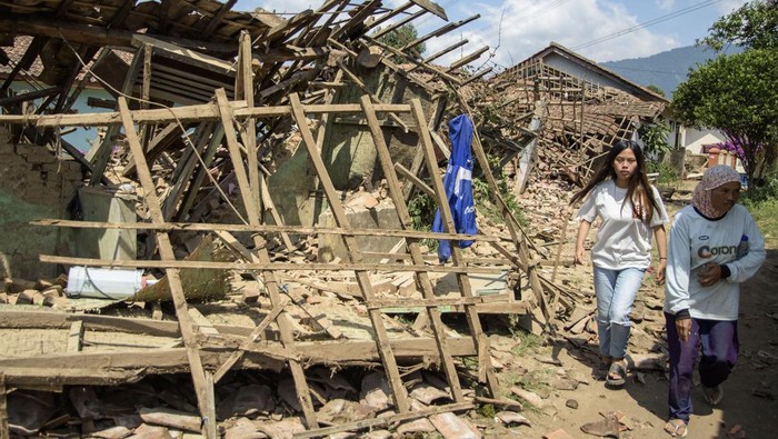 Dampak gempa kertasari Kabupaten Bandung Warga melintas di dekat rumah yang rusak pascagempa bumi di Desa Cibeureum, Kertasari, Kabupaten Bandung, Jawa Barat, Rabu (18/9/2024). Menurut data sementara BPBD Provinsi Jawa Barat, gempa berkekuatan 5.0 Magnitudo tersebut mengakibatkan 8 unit rumah, 2 fasilitas kesehatan, 1 sarana pendidikan, dan 1 tempat ibadah mengalami kerusakan. ANTARA FOTO/Novrian Arbi/Spt.