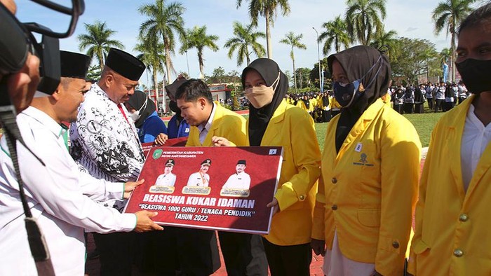 Bupati Kukar Edi Damansyah saat menyerahkan beasiswa kepada 1000 guru dan tenaga pendidikan.
