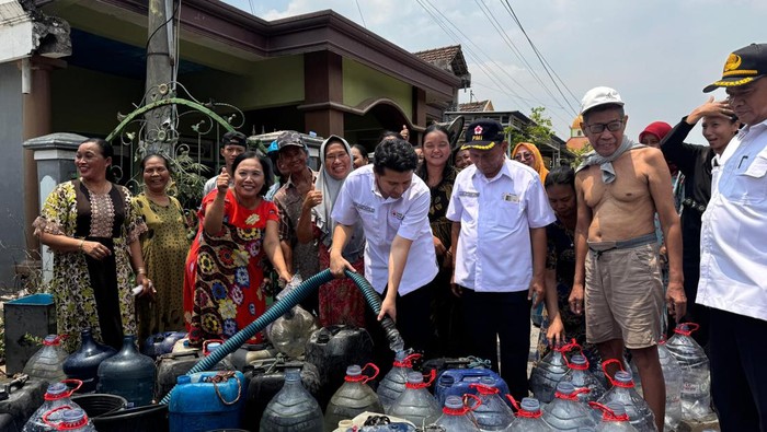 Emil Dardak bersama Imam Utomo saat turut mendistribusikan air bersih untuk warga Cerme, Gresik.