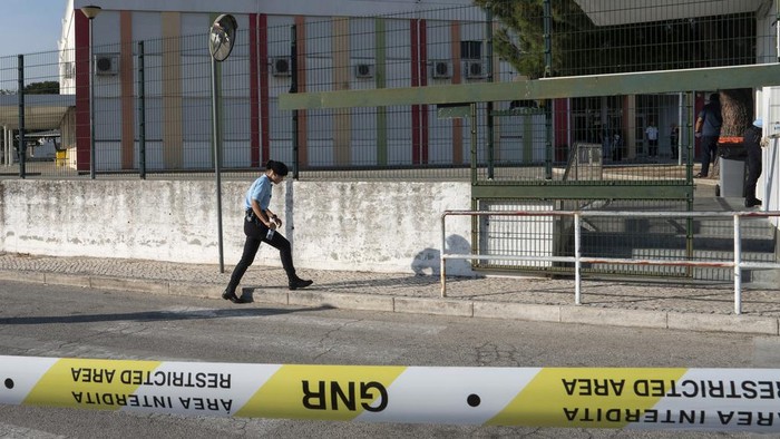 Geger Bocah 12 Tahun Tikam 6 Siswa di Sekolah Portugal A police officer kisses a girl outside a school where a 12-year-old boy stabbed and injured six other children in Azambuja, near Lisbon, Tuesday, Sept. 17, 2024. (AP Photo/Ana Brigida)