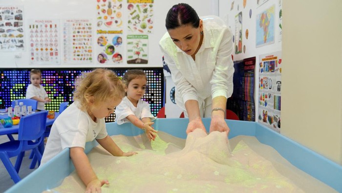Girls and their teacher draw on an interactive floor at the Friendly nursery in Dubai, United Arab Emirates, September 10, 2024. REUTERS/Nabila Eltigi