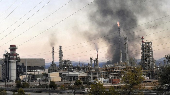 Fire burns at a major oil refinery that prompted Greek authorities to issue an evacuation alert for the surrounding area, near the seaside town of Agii Theodori, some 70 kilometers (40 miles) from Athens, Greece, Tuesday, Sept. 17, 2024. (AP Photo/Vasilis Psomas)