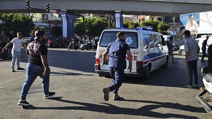 People gather outside the American University hospital after the arrival of several people who were wounded by exploding handheld pagers, in Beirut, Lebanon, Tuesday, Sept. 17, 2024. (AP Photo/Hassan Ammar)