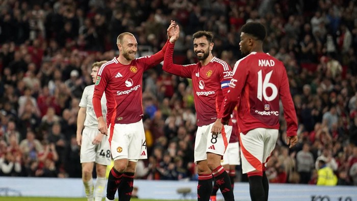 Manchester Uniteds Christian Eriksen, left, celebrates with Manchester Uniteds Bruno Fernandes after he scored his sides 7th goal during the English League Cup soccer match between Manchester United and Barnsley at Old Trafford, Manchester, England, Tuesday, Sept. 17, 2024. (AP Photo/Dave Thompson)