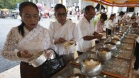 Para umat Buddha mengambil makanan selama perayaan Pchum Ben.