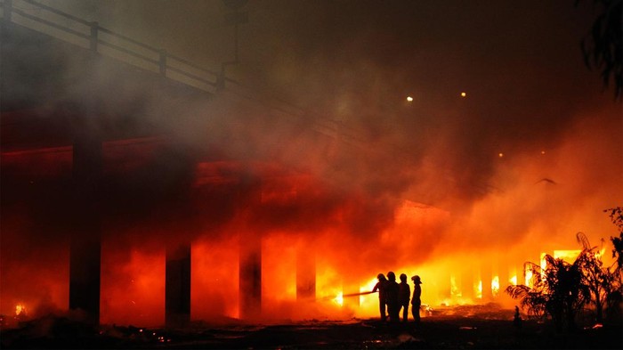 Petugas Dinas Pemadam Kebakaran dan Penyelamatan (DPKP) Kota Surabaya berusaha memadamkam api yang membakar kawasan Tambak Pring, Surabaya, Jawa Timur, Rabu (18/9/2024). Sebanyak 17 kendaraan pemadam kebakaran dikerahkan untuk memadamkan kebakaran tumpukan kayu dan rongsokan di bawah jalan tol Surabaya-Porong. ANTARA FOTO/Didik Suhartono/agr