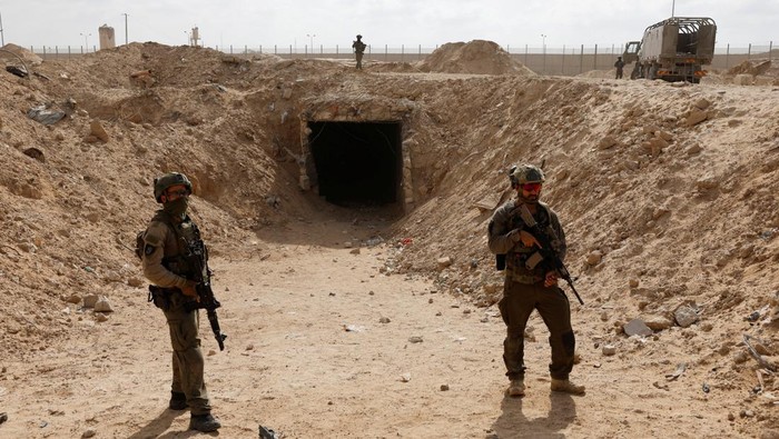 Penampakan Terowongan Gaza Menuju Mesir yang Ditemukan Israel Israeli soldiers stand at the entrance to a tunnel leading to Egypt amid the ongoing conflict between Israel and the Palestinian Islamist group Hamas in the Gaza Strip, in the Philadelphi Corridor area in southern Gaza, September 13, 2024. REUTERS/Amir Cohen EDITOR'S NOTE: REUTERS PHOTOGRAPHS WERE REVIEWED BY THE IDF AS PART OF THE CONDITIONS OF THE EMBED. NO PHOTOS WERE REMOVED. TPX IMAGES OF THE DAY