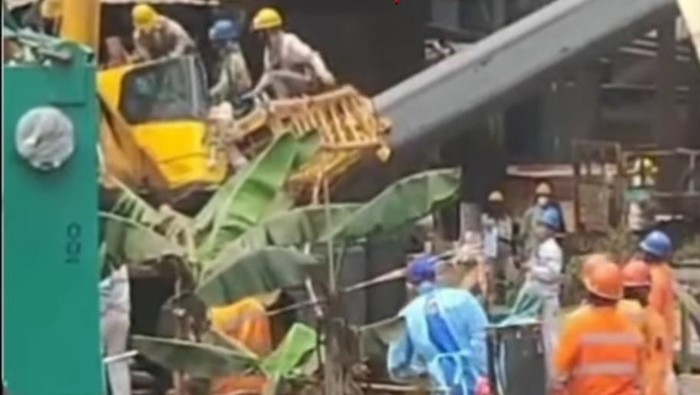 Sejumlah pekerja mengevakuasi operator crane yang tertimpa outrigger. Dokumen Istimewa