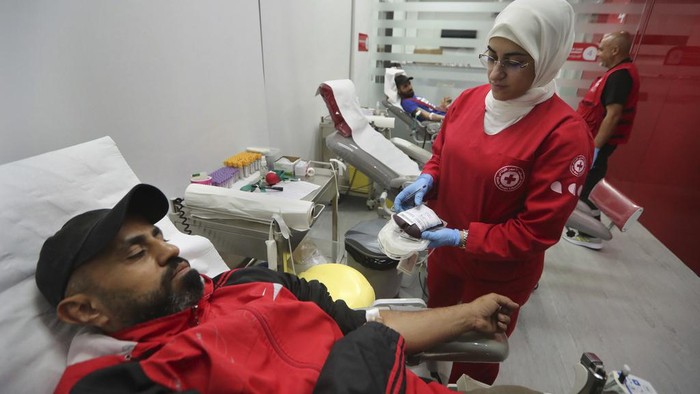 People donate blood for those who were injured by their exploded handheld pagers, at a Red Cross center, in the southern port city of Sidon, Lebanon, Tuesday, Sept. 17, 2024. (AP Photo/Mohammed Zaatari)