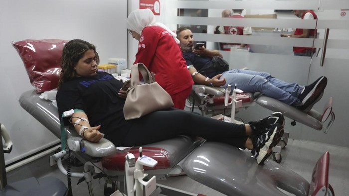 People donate blood for those who were injured by their exploded handheld pagers, at a Red Cross center, in the southern port city of Sidon, Lebanon, Tuesday, Sept. 17, 2024. (AP Photo/Mohammed Zaatari)
