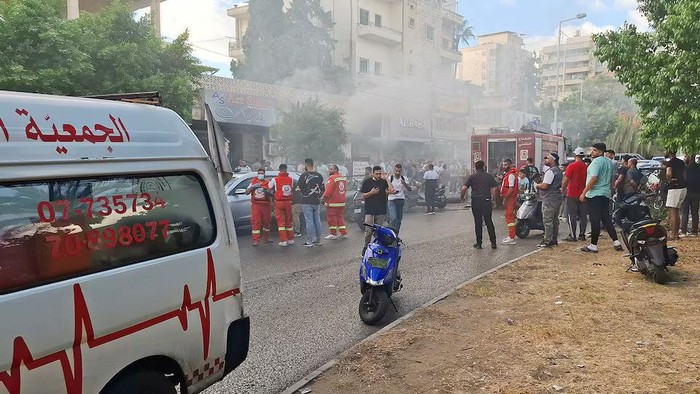 Smoke rises from a mobile shop as civil defence members gather in Sidon, Lebanon September 18, 2024. REUTERS/Hassan Hankir Purchase Licensing Rights
