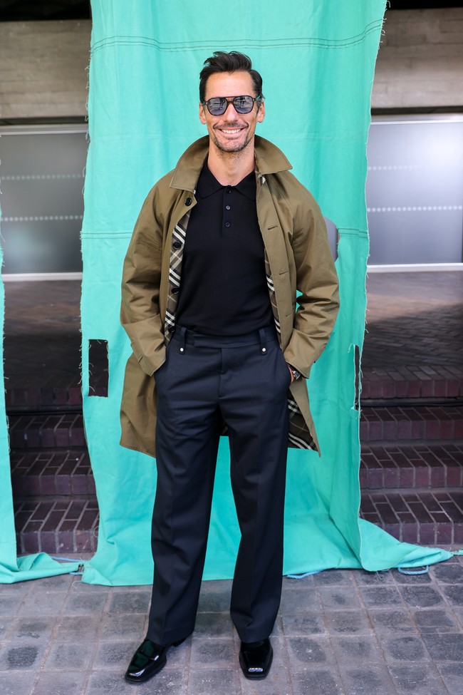 Model David Gandy bersolek dengan gaya dandy dalam padanan polo-shirt hitam, celana dan sepatu formal, berikut jaket parka. (Foto: Dave Benett/Getty Images for Burberry)