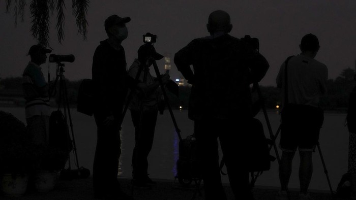 Kala Fotografer China Berburu Momen Bulan Purnama Para penggemar fotografi menyiapkan kamera mereka sambil menunggu untuk mengabadikan bulan purnama di Taman Beihai, Beijing, China, Rabu (18/9/2024).