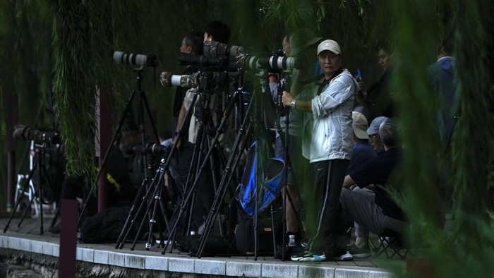 Kala Fotografer China Berburu Momen Bulan Purnama Para penggemar fotografi menyiapkan kamera mereka sambil menunggu untuk mengabadikan bulan purnama di Taman Beihai, Beijing, China, Rabu (18/9/2024).