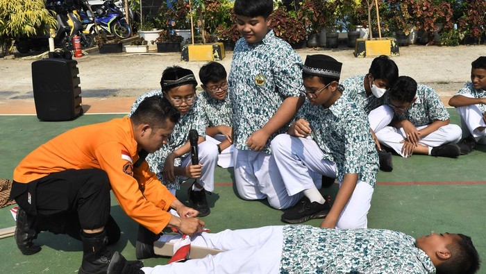 Sejumlah murid SMP Islam PB Soedirman 2 mengikuti simulasi penanganan korban luka akibat gempa bumi di Rawalumbu, Bekasi, Jawa Barat, Kamis (19/9/2024). Simulasi mitigasi bencana gempa bumi yang diselenggarakan BPBD itu sebagai upaya antisipasi serta  meningkatkan kesiapsiagaan dan kemampuan siswa maupun guru dalam penanganan bencana gempa bumi. ANTARA FOTO/Fakhri Hermansyah/tom.
