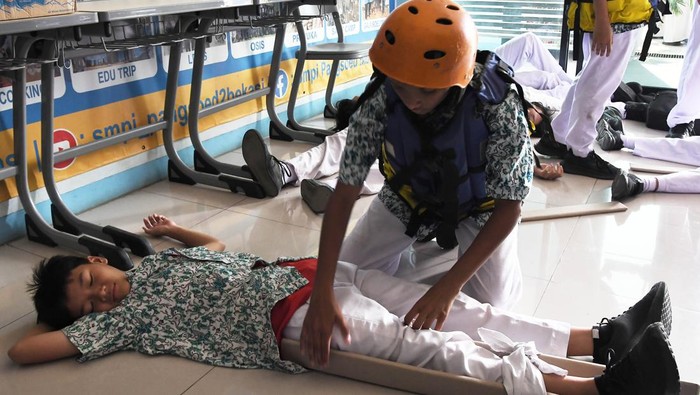 Sejumlah murid SMP Islam PB Soedirman 2 mengikuti simulasi penanganan korban luka akibat gempa bumi di Rawalumbu, Bekasi, Jawa Barat, Kamis (19/9/2024). Simulasi mitigasi bencana gempa bumi yang diselenggarakan BPBD itu sebagai upaya antisipasi serta  meningkatkan kesiapsiagaan dan kemampuan siswa maupun guru dalam penanganan bencana gempa bumi. ANTARA FOTO/Fakhri Hermansyah/tom.