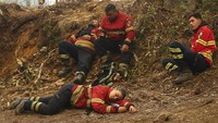 Tampak para petugas pemadam kebakaran kelelahan dan beristirahat sejenak.
