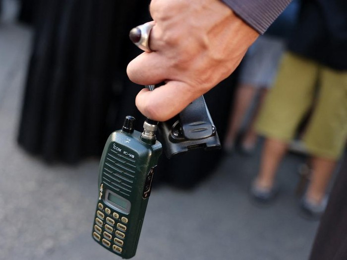 A man holds a walkie talkie device after he removed the battery during the funeral of persons killed when hundreds of paging devices exploded in a deadly wave across Lebanon the previous day, in Beiruts southern suburbs on September 18, 2024. Hundreds of pagers used by Hezbollah members exploded across Lebanon on September 17, killing at least nine people and wounding around 2,800 in blasts the Iran-backed militant group blamed on Israel. (Photo by ANWAR AMRO / AFP)