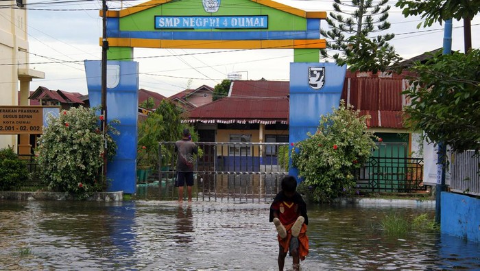 Seorang warga berada didalam rumahnya yang terendam banjir pasang air laut (rob) di Kota Dumai, Riau, Jumat (20/9/2024). Puncak pasang air laut setinggi 3.61 meter pada pagi hari ini ditambah dengan tidak berfungsinya pompa dan pintu air menyebabkan banjir rob meluas merendam fasilitas umum serta permukiman warga, sehingga sejumlah sekolah terpaksa meliburkan siswanya, pertokoan tutup dan aktivitas warga terganggu. ANTARA FOTO/Aswaddy Hamid/foc.