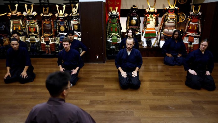 Tourists from abroad take part in a Japanese sword-cutting experience at Samurai Theater Tokyo in Tokyo, Japan September 17, 2024.   REUTERS/Issei Kato