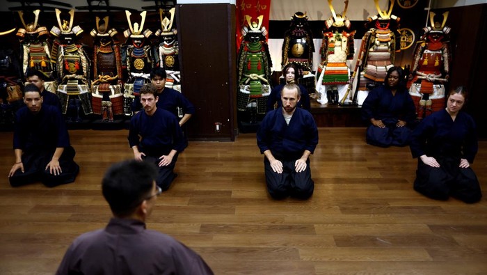 Demam Shogun Bikin Pusat Latihan Samurai di Jepang Ramai Turis Tourists from abroad take part in a Japanese sword-cutting experience at Samurai Theater Tokyo in Tokyo, Japan September 17, 2024. REUTERS/Issei Kato