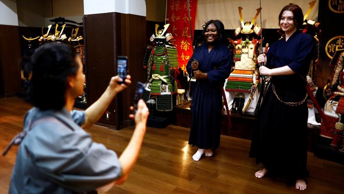 Demam Shogun Bikin Pusat Latihan Samurai di Jepang Ramai Turis Tourists from abroad take part in a Japanese sword-cutting experience at Samurai Theater Tokyo in Tokyo, Japan September 17, 2024. REUTERS/Issei Kato