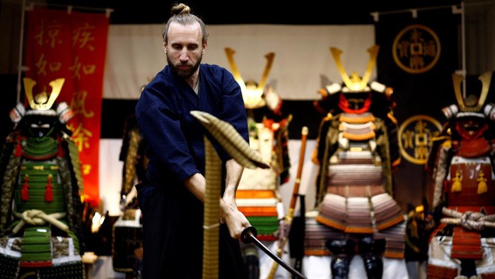 Tourists from abroad take part in a Japanese sword-cutting experience at Samurai Theater Tokyo in Tokyo, Japan September 17, 2024.   REUTERS/Issei Kato