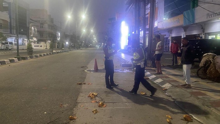 Polisi melakukan olah TKP kecelakaan Pajero tabrak pedagang bermotor.