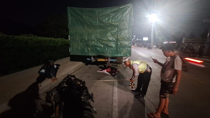 Polisi saat melakukan olah TKP di lokasi pemotor yang tabrak truk berhenti di pinggir jalan