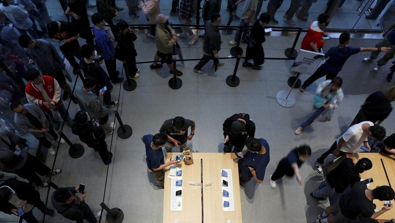 Staff members attend to customers as the new iPhone 16 series smartphones go on sale at an Apple store in Beijing, China September 20, 2024. REUTERS/Florence Lo