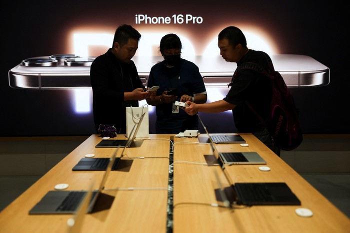 Staff members attend to customers as the new iPhone 16 series smartphones go on sale at an Apple store in Beijing, China September 20, 2024. REUTERS/Florence Lo