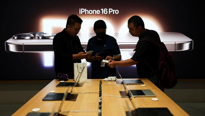 Staff members attend to customers as the new iPhone 16 series smartphones go on sale at an Apple store in Beijing, China September 20, 2024. REUTERS/Florence Lo