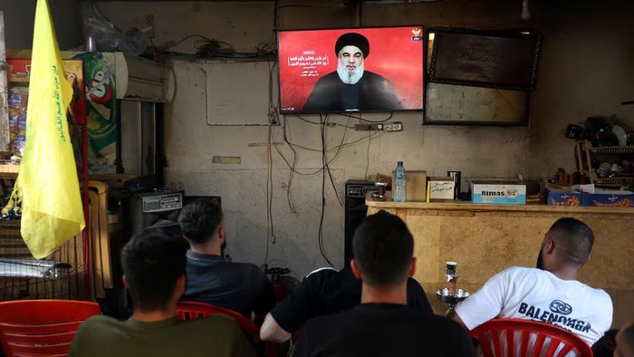 People watch Lebanons Hezbollah leader Sayyed Hassan Nasrallah delivering a televised address, as they sit at a cafe in Sidon, Lebanon September 19, 2024. REUTERS/Aziz Taher Purchase Licensing Rights