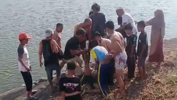 Warga memberi pertolongan ke siswa SMK tenggelam di waduk tunggu Pampang.