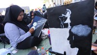 Seorang mahasiswa baru Universitas Muhammadiyah (UM) mengikuti aksi melukis bersama di Surabaya, Jawa Timur, pada Sabtu (21/9/2024).