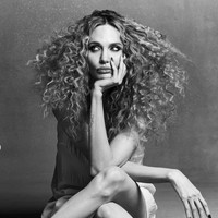 Dalam salah satu foto, mantan istri aktor Brad Pitt ini pose duduk bersila dengan gaun sutra dan manikur hitam runcing. Foto: Dok. CR Fashion Book