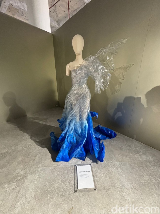 Gaun transparan yang dipadukan dengan warna biru pada bagian bawahnya ini merupakan karya dari desainer Monica Ivena. Uniknya gaun tersebut terbuat dari mika sarung gaun yang sudah rusak. Foto: Vina Oktiani/Wolipop