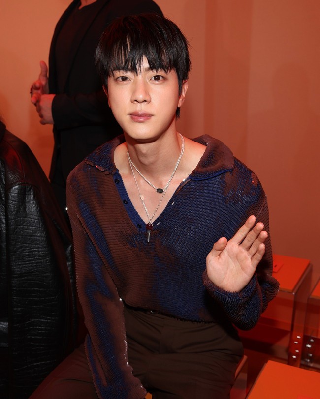Dalam kesempatan itu, Jin BTS tampil menawan dalam balutan knitted sweater bernuansa oranye-biru, potongan celana coklat, sepatu loafers dan belt hitam. Foto: Getty Images